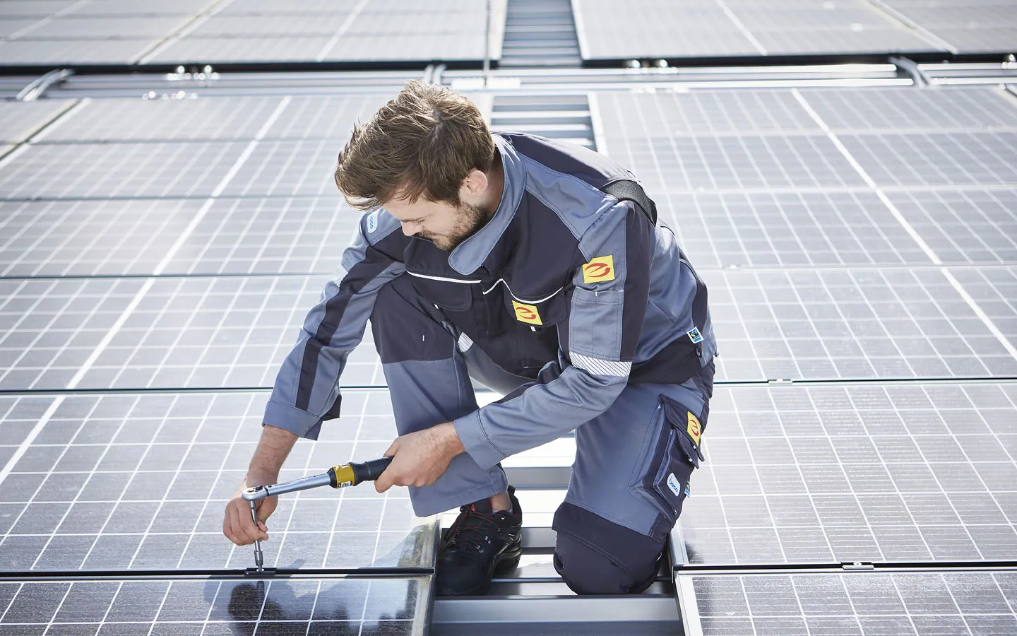 E-CHECK E-Mobilität - Mitarbeiter montiert auf dem Dach die neuen Solarmodule · Winter Elektro